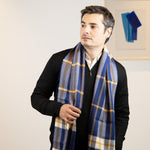 Mann mit grauen Haaren trägt den eleganten Schottenkaro Schal in blau von Alpakin aus feiner Alpakawolle
