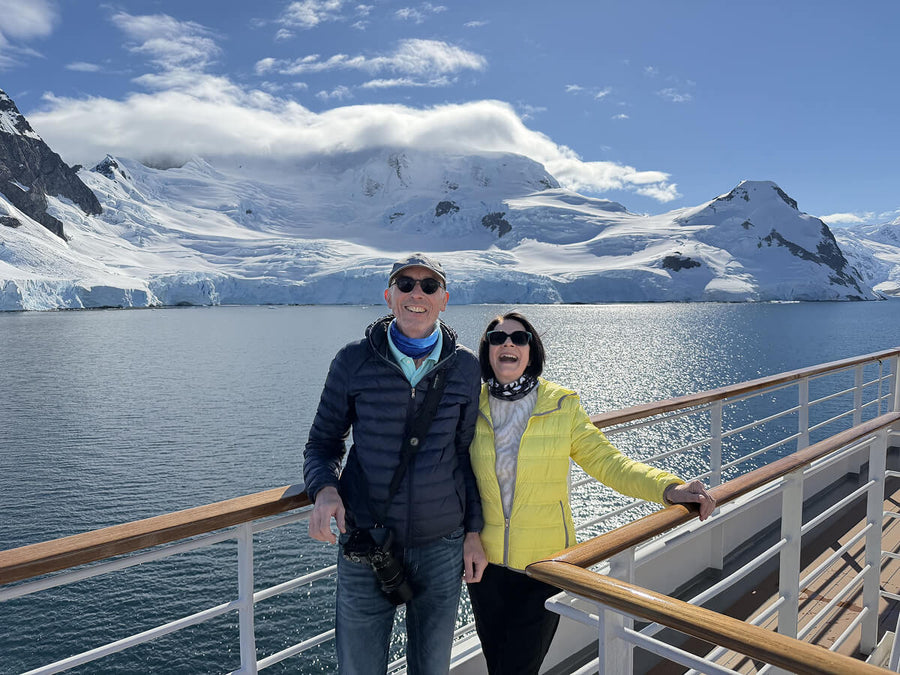 Die beiden Alpakin Kunden Solveig und Reinhard auf ihrem Antarktis Expeditionsschiff mit Gletscher im Hintergrund
