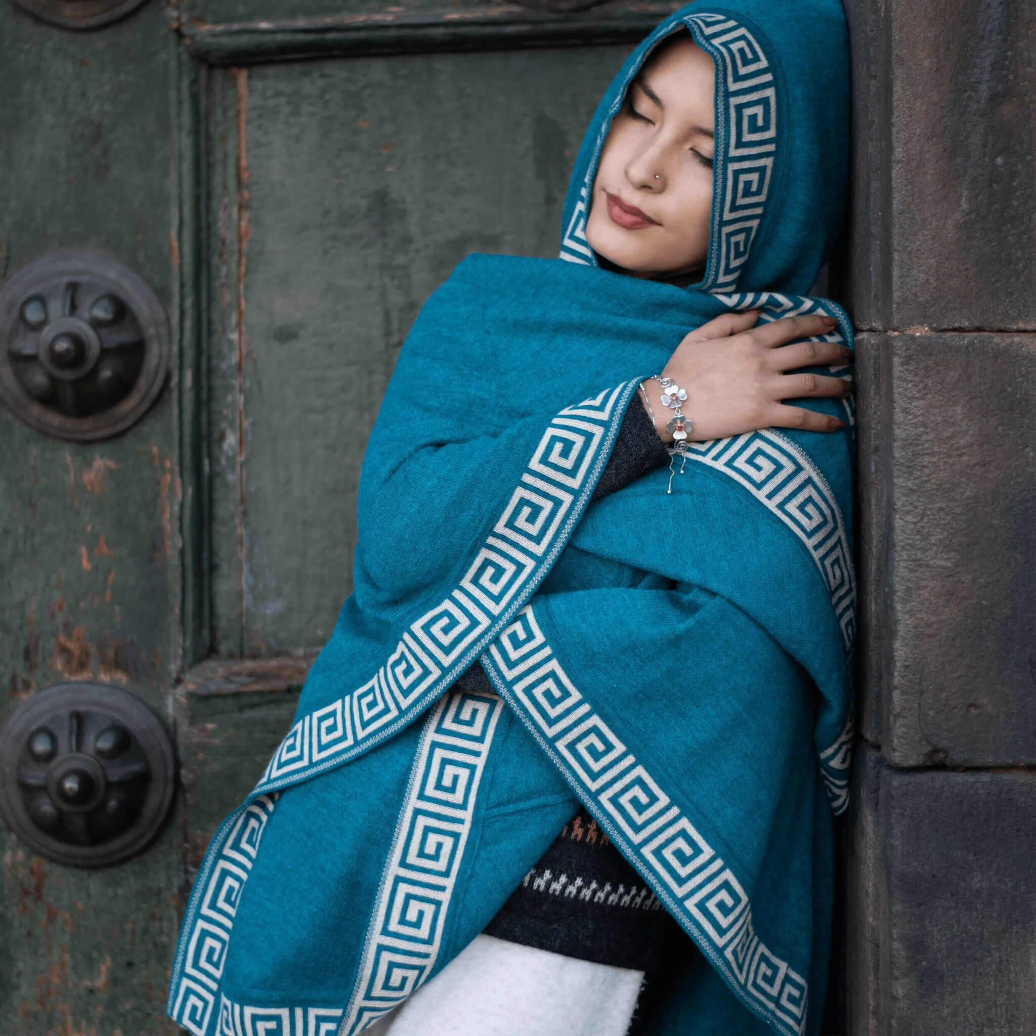Alpaka Poncho mit Kapuze Luz für Damen von Alpakin in dunkeltürkis, getragen von Model