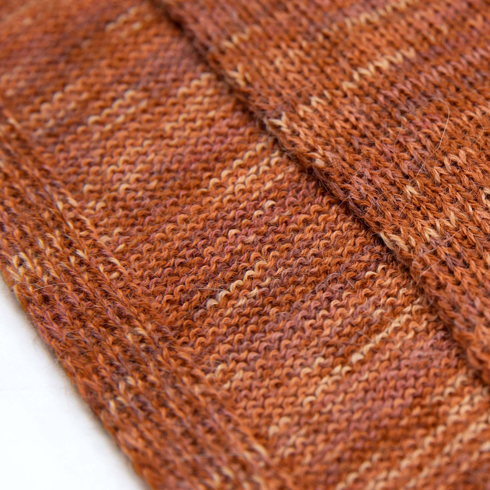 Dunkelorange-farbiges Textil mit Akzenten der Sumita Tunika aus 100% Babyalpaka