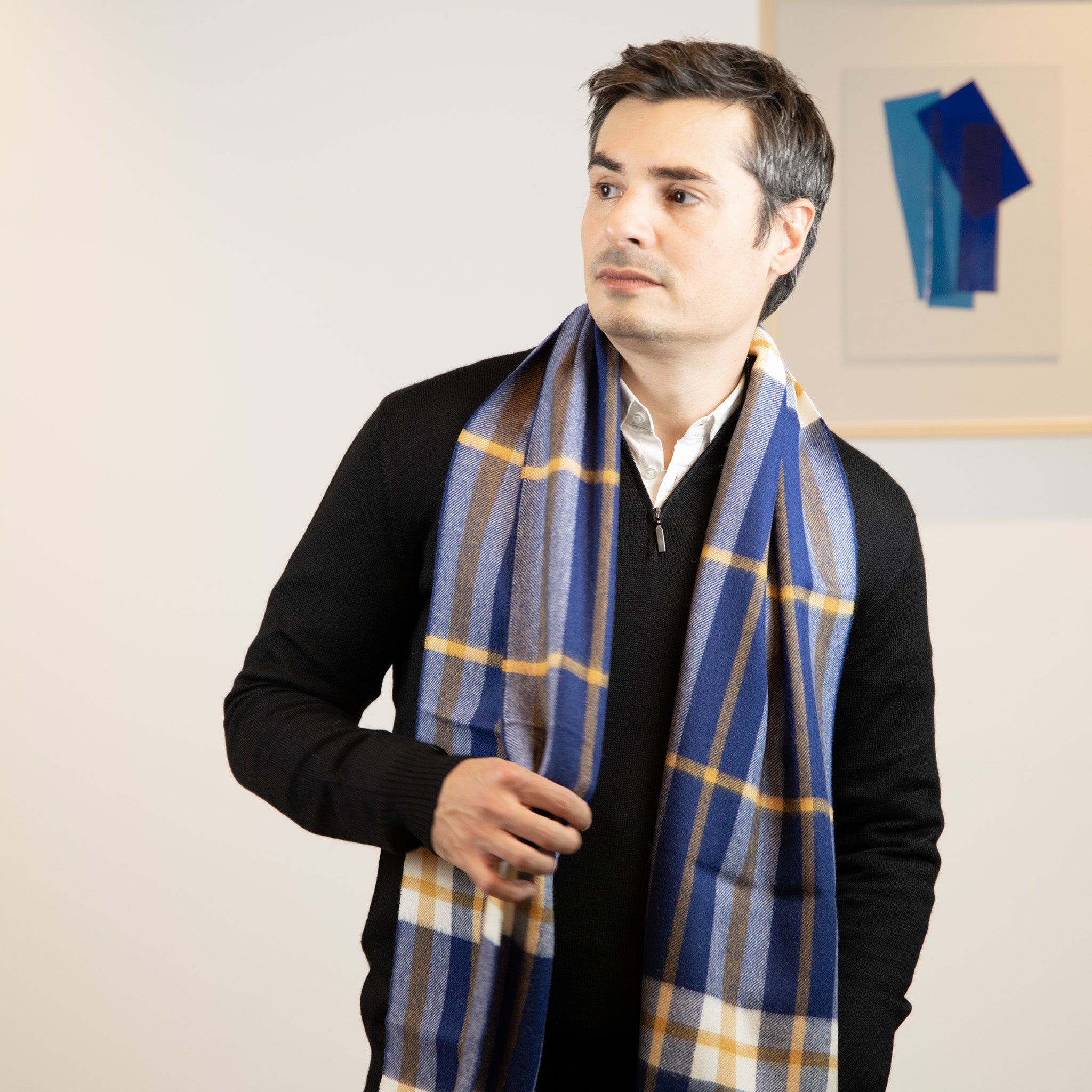 Mann mit grauen Haaren trägt den eleganten Schottenkaro Schal in blau von Alpakin aus feiner Alpakawolle