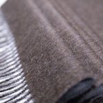 Nahaufnahme Textil des zweifarbigen Alpaka Schals in dunkelbraun mit Fransensaum