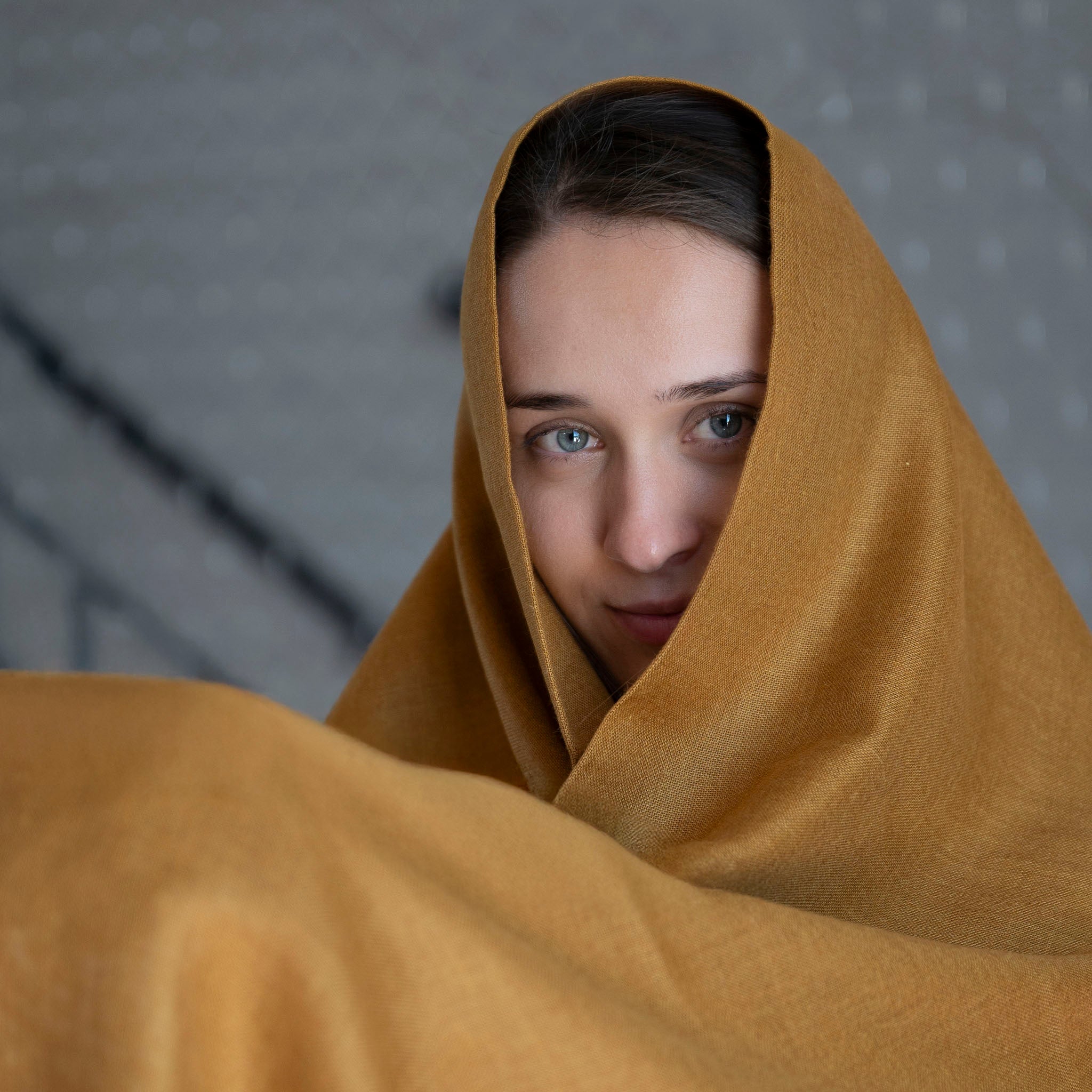 Glänzender Alpaka Seide Schal für Damen als großes Schultertuch in senfgelb, getragen von dunkelhaarigem Model