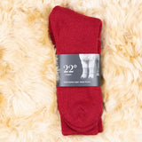 Alpaka Wintersocken in rot, verpackt und liegend auf weichem Alpakafell