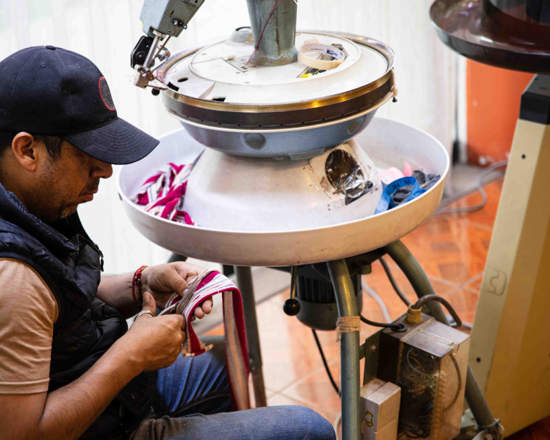 Schneider Alex aus Peru arbeitet mit Schere an Textil