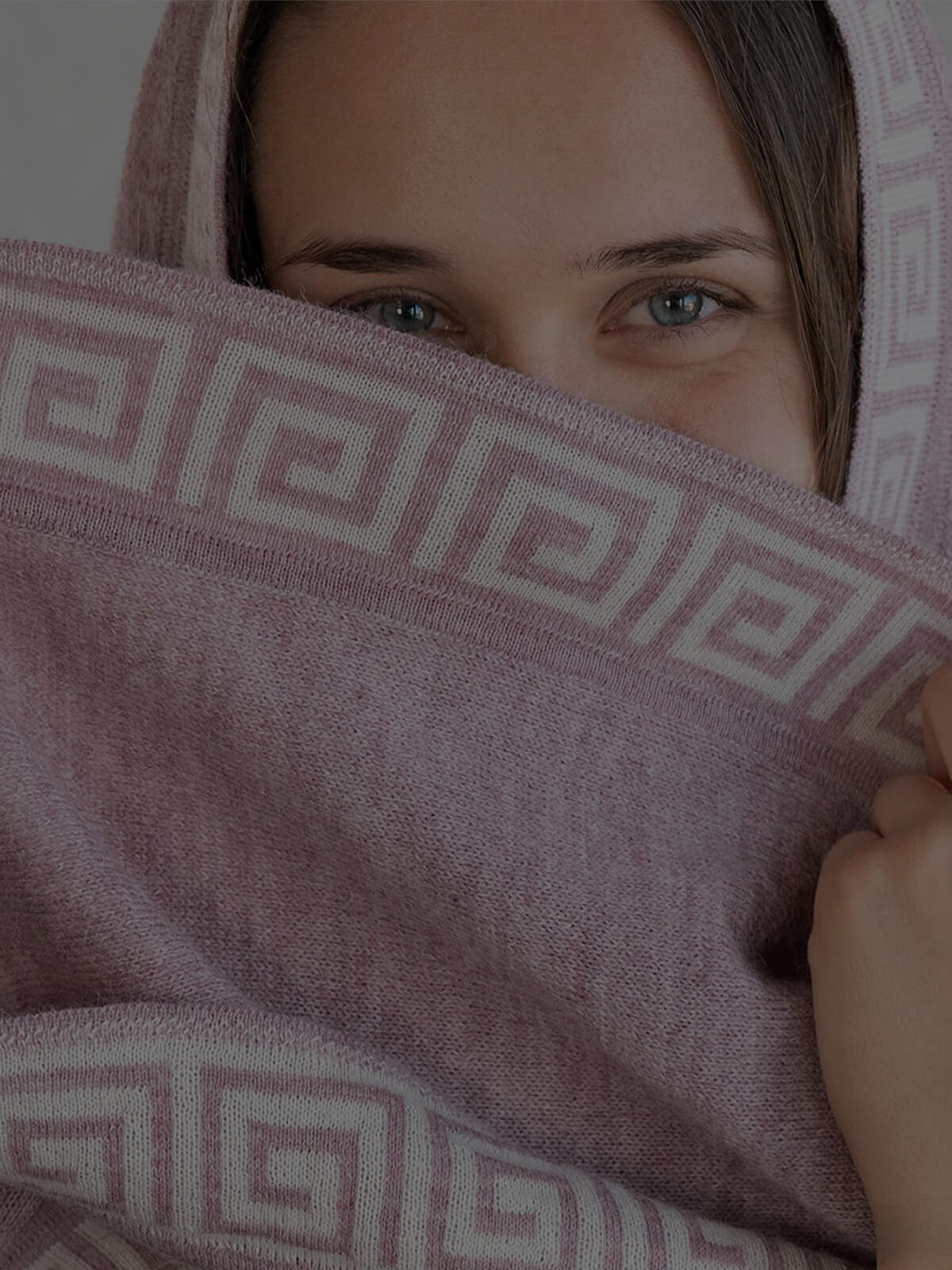 Rosafarbiger Alpaka Poncho aus sanfter Alpakawolle, getragen von dunkelhaariger Frau