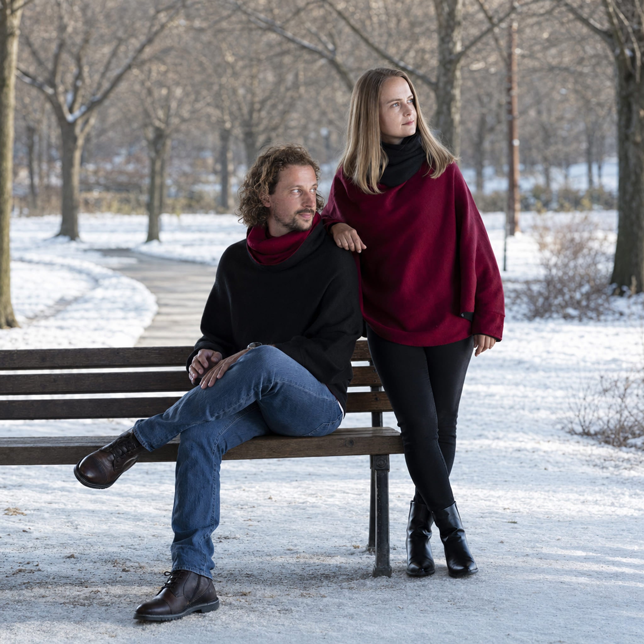 Mann und Frau tragen den warmen Unisex Wendeponcho draußen im Park vor winterlicher Kulisse