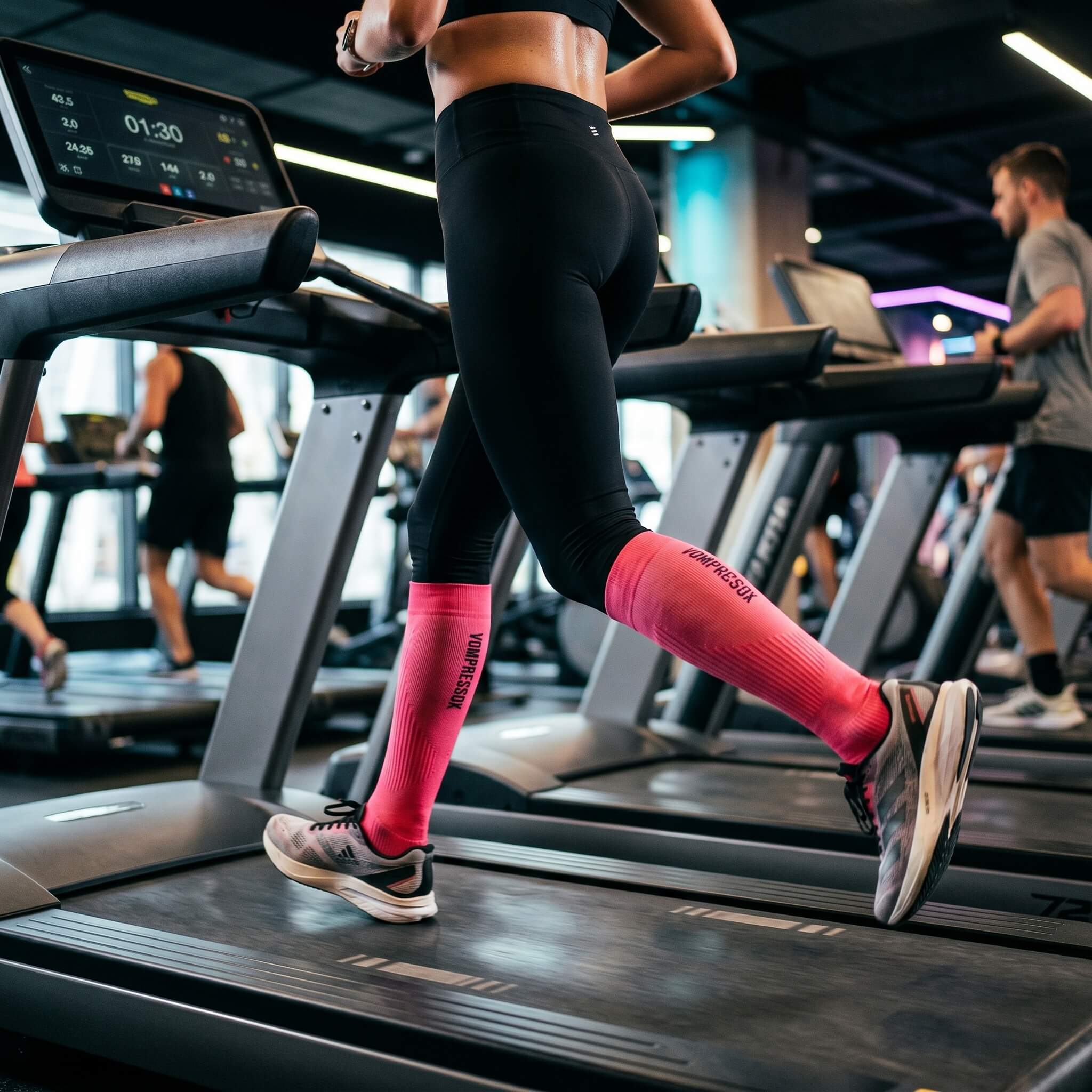 Frau trägt pinke Kompressionsstrümpfe auf dem Laufband
