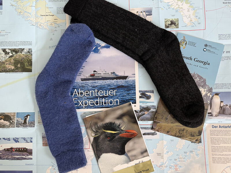 Reiseovorbereitung in die Antarktis mit wärmsten Alpaka Socken, Landkarte und Flyern