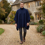 Mann laufend im eleganten Herren Poncho vor britischem Landhaus
