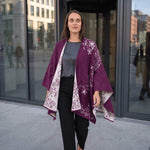 Frau laufend mit dem Alpaka Wendeponcho Tamaya, sodass man den schönen Fall des eleganten Ponchos sieht