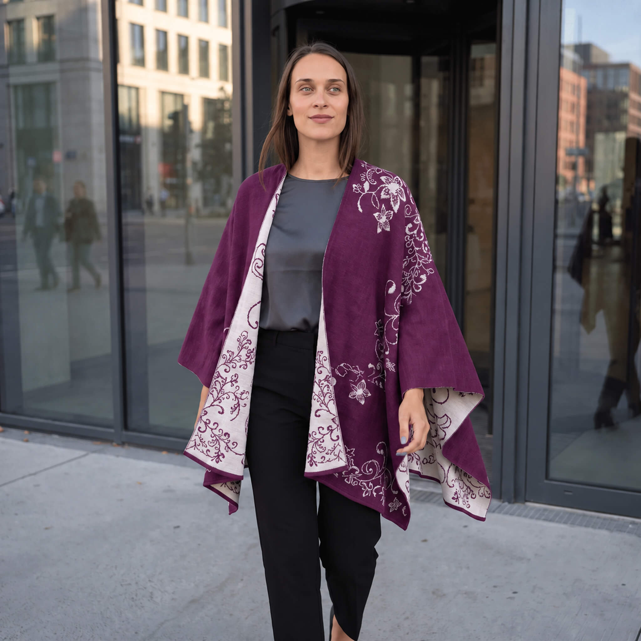 Frau laufend mit dem Alpaka Wendeponcho Tamaya, sodass man den schönen Fall des eleganten Ponchos sieht